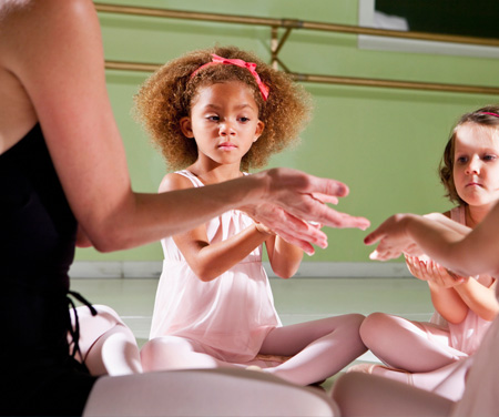 Dance students sitting with teacher